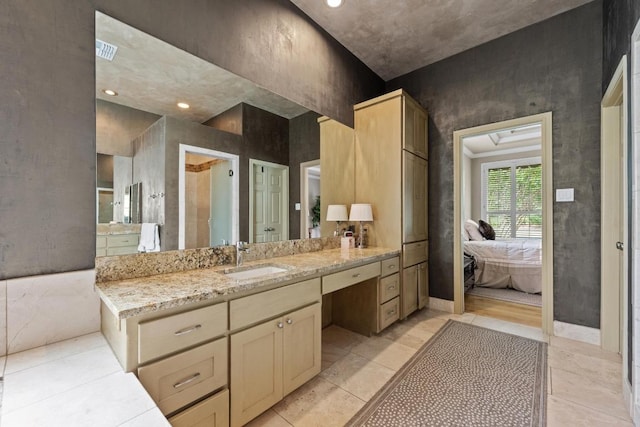 ensuite bathroom with vanity, ensuite bath, and visible vents