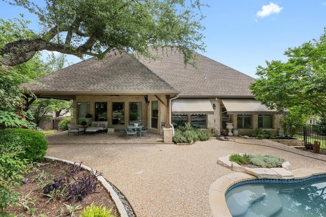 back of property with roof with shingles, fence, a fenced in pool, and a patio area