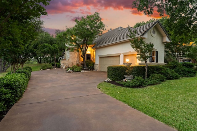 109 Lost Spur, Horseshoe Bay, TX 78657 - view of front of property featuring stucco siding, concrete driveway, an attached garage, a front lawn, and stone siding
