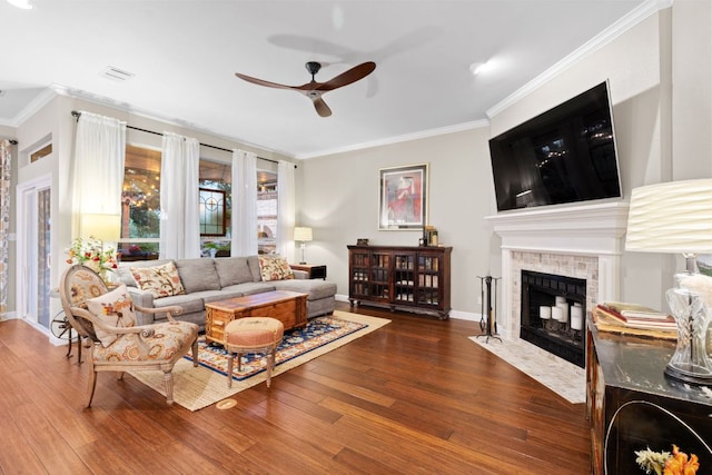 109 Lost Spur, Horseshoe Bay, TX 78657 - living room with ceiling fan, wood finished floors, crown molding, a tiled fireplace, and baseboards