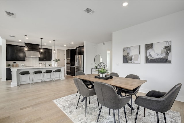 dining room with light wood-style floors, recessed lighting, and visible vents