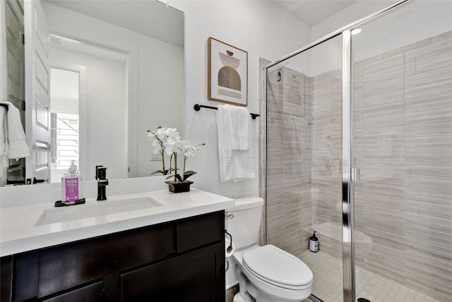 bathroom featuring vanity, toilet, and a stall shower