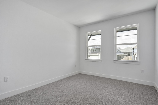 empty room featuring carpet flooring and baseboards
