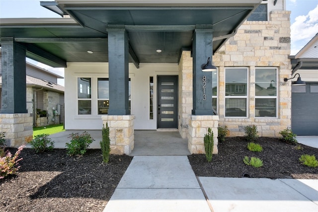 entrance to property with covered porch and stone siding