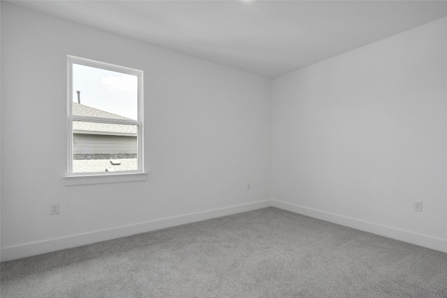 carpeted spare room with baseboards