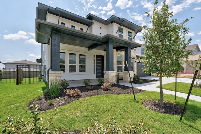 view of front of home with fence, covered porch, a front lawn, and stone siding