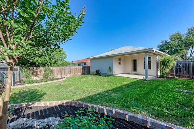 back of house with a lawn, a fenced backyard, a patio area, and stucco siding