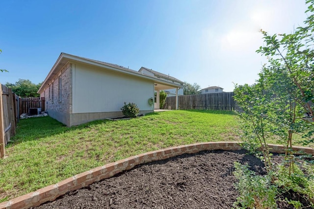 view of yard featuring a fenced backyard and central AC