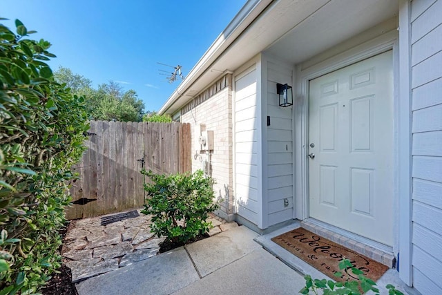 view of exterior entry featuring fence