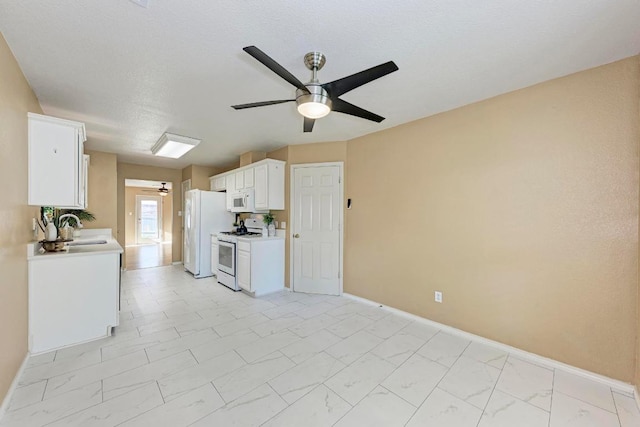kitchen with ceiling fan, light countertops, a sink, white appliances, and white cabinetry
