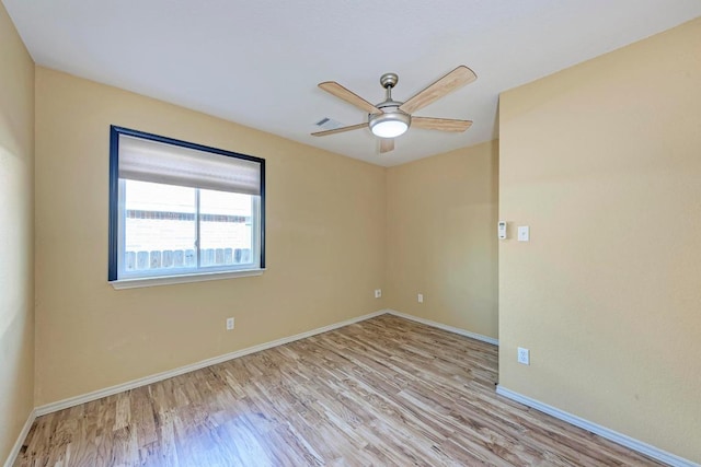 spare room featuring baseboards, ceiling fan, and wood finished floors