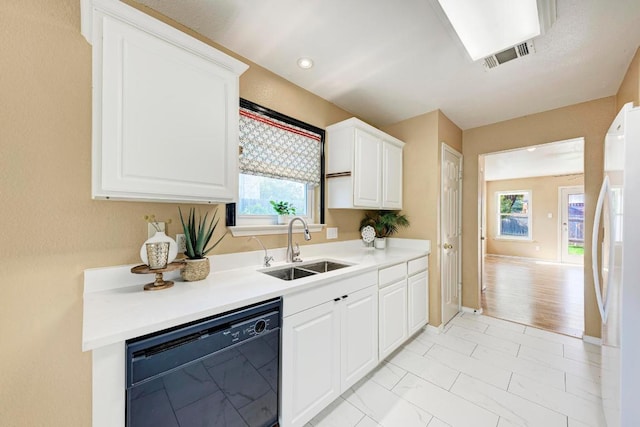 kitchen featuring visible vents, dishwasher, a sink, light countertops, and freestanding refrigerator