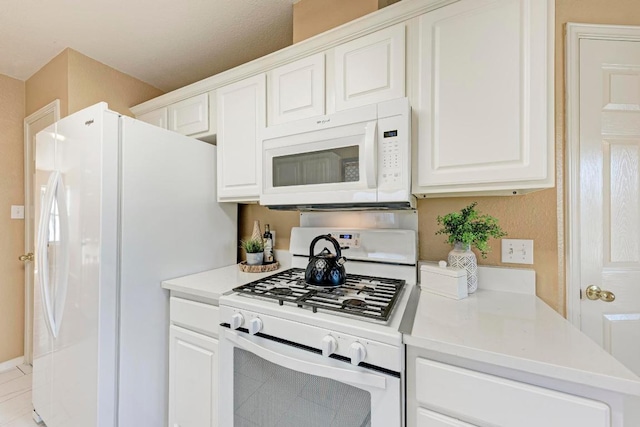 kitchen with light countertops, white appliances, and white cabinetry