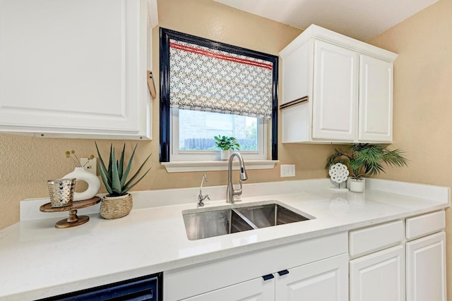 kitchen featuring a sink, light countertops, white cabinets, and dishwasher