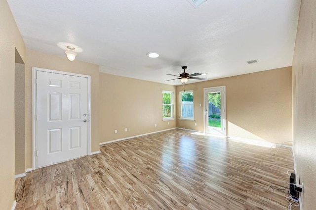 spare room featuring a ceiling fan, baseboards, visible vents, and wood finished floors