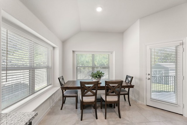dining space with baseboards, light tile patterned flooring, and vaulted ceiling