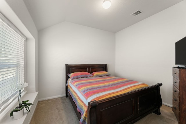 bedroom featuring light colored carpet, baseboards, and lofted ceiling