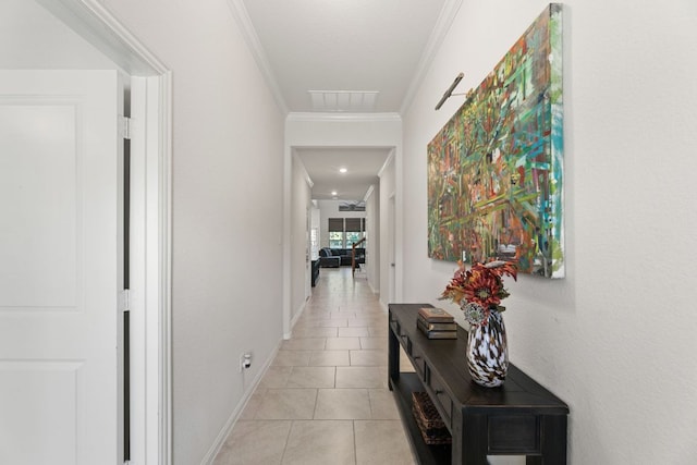 hallway featuring baseboards, visible vents, ornamental molding, and light tile patterned floors