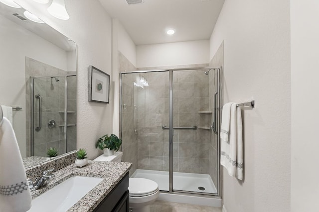 full bath featuring vanity, tile patterned floors, a stall shower, and toilet