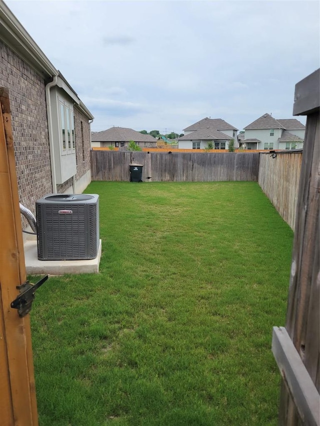 view of yard with central AC unit and a fenced backyard