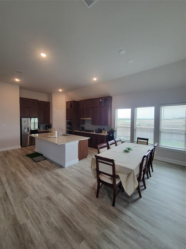 dining space with baseboards, recessed lighting, and light wood-style flooring