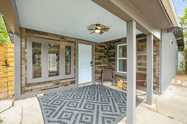 entrance to property featuring ceiling fan and stone siding