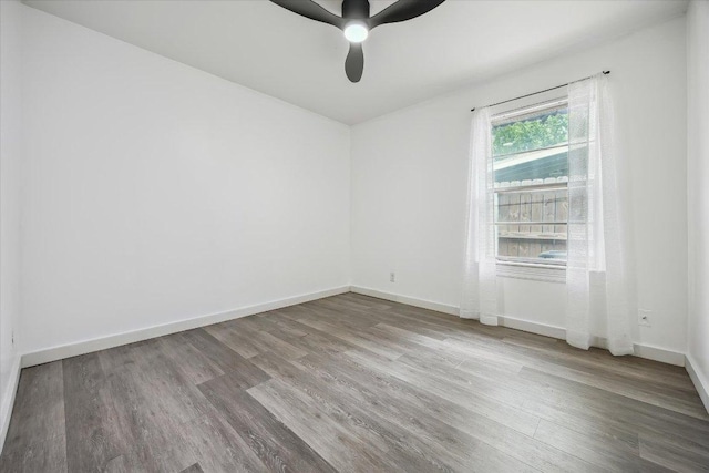 empty room featuring baseboards, a ceiling fan, and wood finished floors