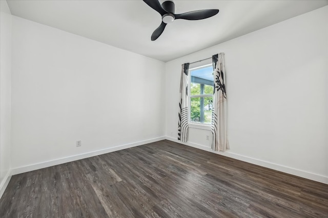 spare room with baseboards, a ceiling fan, and dark wood finished floors