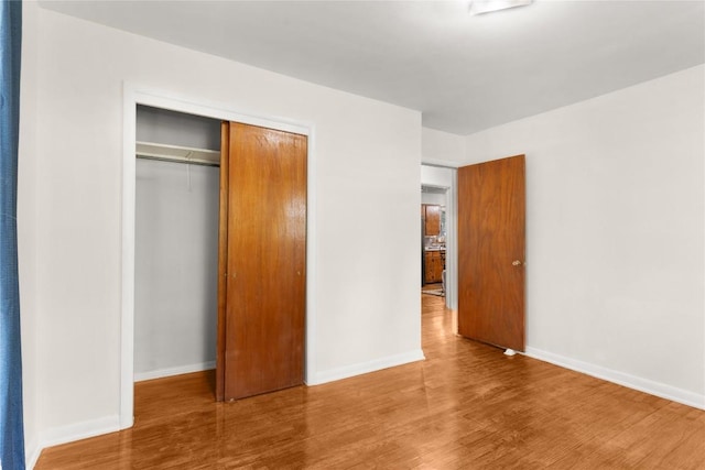 607 Gilmore St, Taylor, TX 76574 - unfurnished bedroom with baseboards, wood finished floors, and a closet