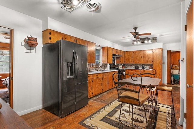 607 Gilmore St, Taylor, TX 76574 - kitchen featuring brown cabinetry, gas stove, a ceiling fan, and black fridge