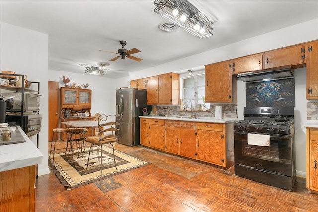 607 Gilmore St, Taylor, TX 76574 - kitchen featuring ceiling fan, a sink, stainless steel fridge with ice dispenser, black gas range oven, and under cabinet range hood