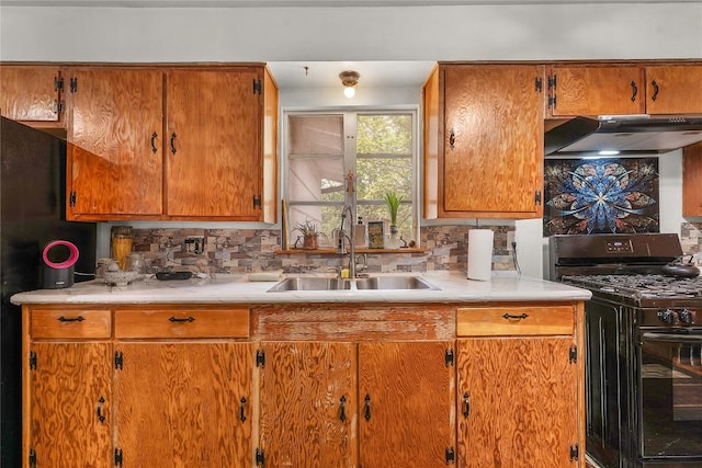 607 Gilmore St, Taylor, TX 76574 - kitchen featuring under cabinet range hood, tasteful backsplash, a sink, and black range with gas stovetop