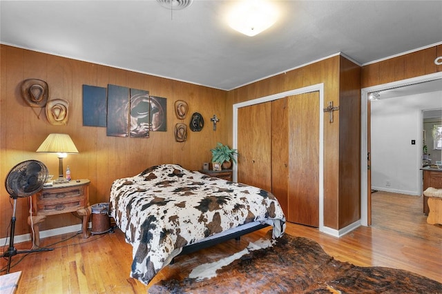 607 Gilmore St, Taylor, TX 76574 - bedroom featuring wooden walls, baseboards, a closet, and wood finished floors