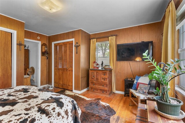 607 Gilmore St, Taylor, TX 76574 - bedroom featuring wooden walls, baseboards, ornamental molding, and wood finished floors