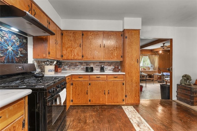 607 Gilmore St, Taylor, TX 76574 - kitchen featuring black range with gas cooktop, brown cabinetry, backsplash, dark wood-style flooring, and under cabinet range hood