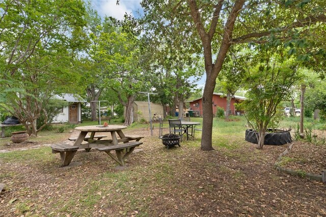 607 Gilmore St, Taylor, TX 76574 - view of yard with an outbuilding, a storage unit, and an outdoor fire pit