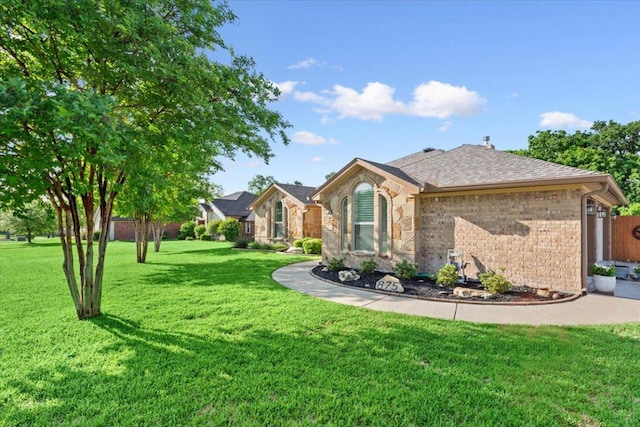 view of front facade with brick siding and a front yard