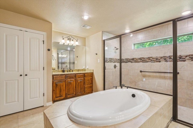 bathroom with a garden tub, vanity, a textured ceiling, tile patterned floors, and a stall shower