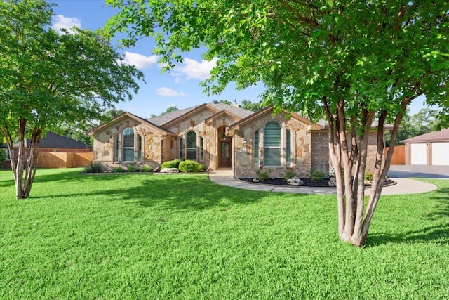 view of front of property with fence, a front yard, and stone siding