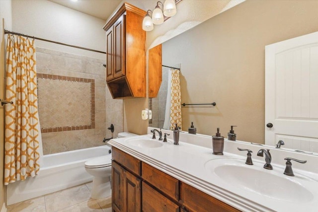 bathroom with double vanity, a sink, tile patterned floors, and toilet