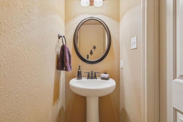 bathroom with a textured wall and a sink