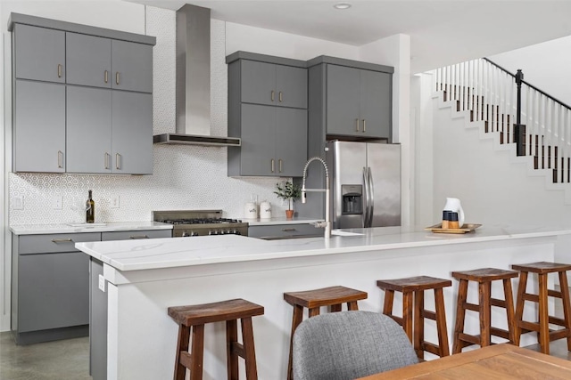 5510 Woodrow Ave Unit 1, Austin, TX 78756 - kitchen featuring stove, a breakfast bar area, wall chimney exhaust hood, stainless steel fridge with ice dispenser, and gray cabinetry