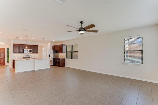 182 Lone Tree Holw, Buda, TX 78610 - unfurnished living room with plenty of natural light, a ceiling fan, baseboards, light tile patterned floors, and recessed lighting