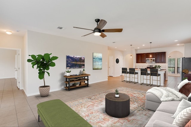 182 Lone Tree Holw, Buda, TX 78610 - living room featuring light tile patterned floors, ceiling fan, baseboards, arched walkways, and recessed lighting