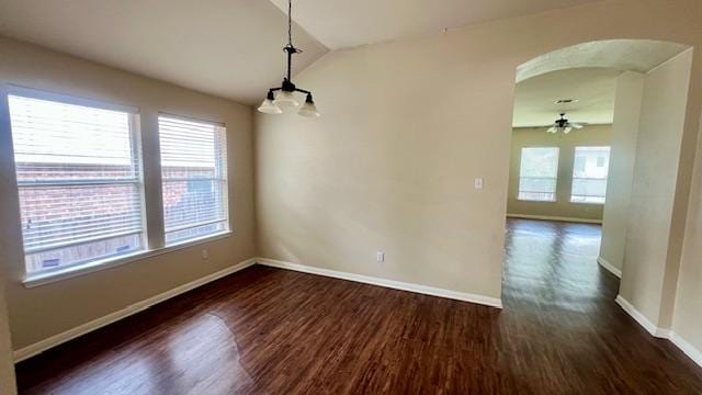 unfurnished dining area with arched walkways, a ceiling fan, baseboards, lofted ceiling, and dark wood-type flooring