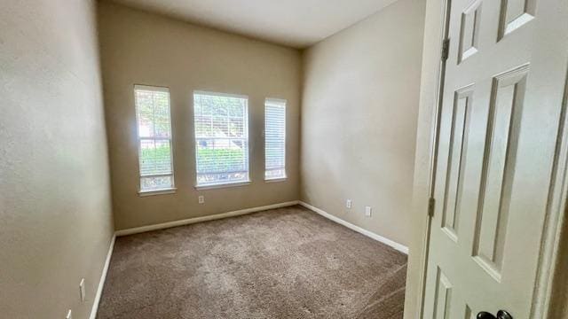 empty room with baseboards and carpet