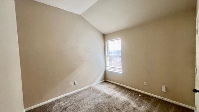 carpeted empty room with baseboards and lofted ceiling