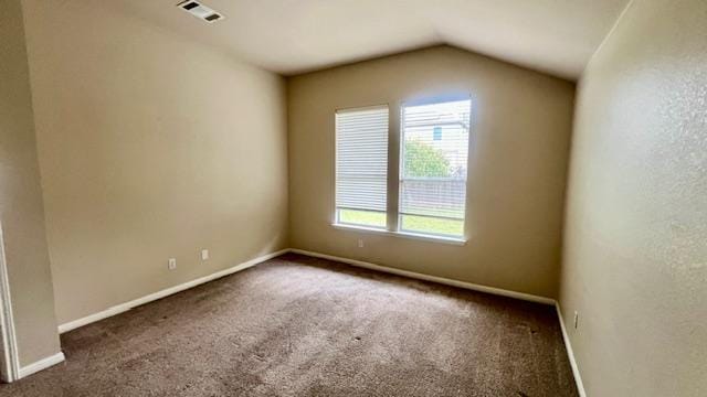 carpeted spare room with baseboards, visible vents, and lofted ceiling