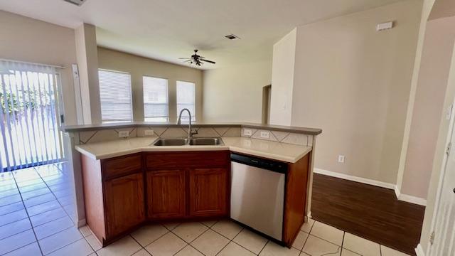 kitchen with a sink, a wealth of natural light, a ceiling fan, and dishwasher
