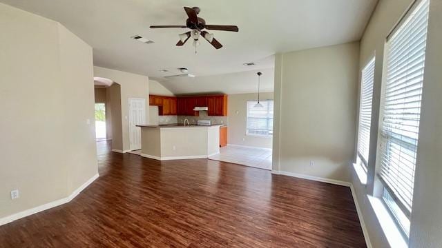 unfurnished living room with dark wood finished floors, a ceiling fan, baseboards, lofted ceiling, and visible vents